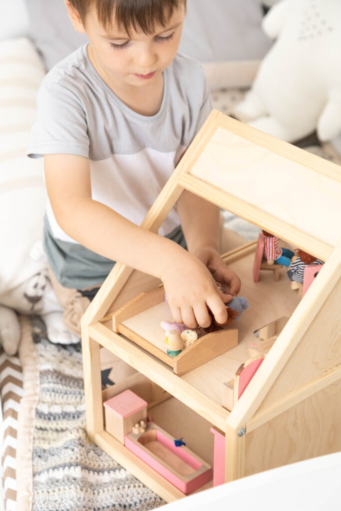 Non,Binary,Diverse,Male,Kid,Playing,Wooden,Dolls,House,Enjoy